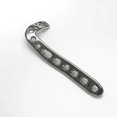 Anterolateral Distal Tibia Locking Plate in a silver-colored, reflective metal, seen from above with a curved head of clustered holes and the letter L marked near the end of the long shaft.